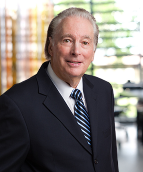 Man in suit with striped tie smiling.